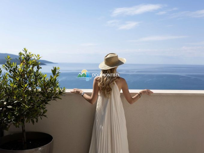 Женщина в шляпе смотрит на море.